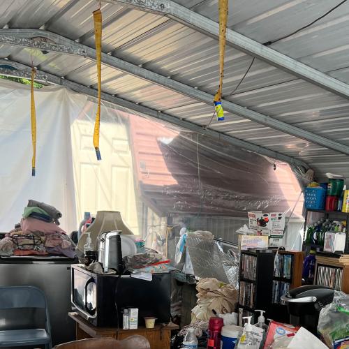 A family moves into their carport after losing their home to July's flooding.