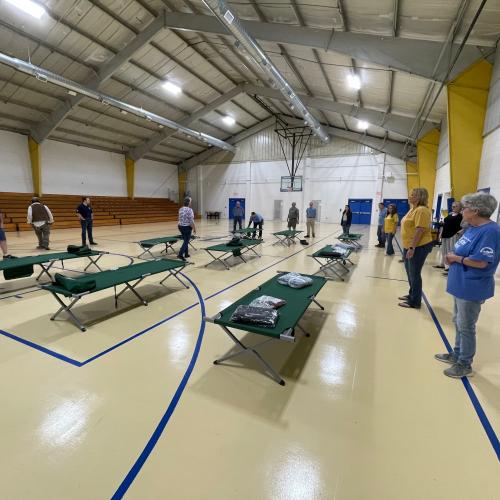 CAP employees, volunteers, and community members learn how to set up cots for emergency shelters.